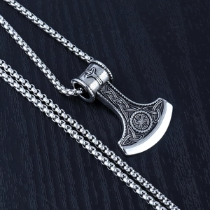 Close-up of vintage steel axe pendant with intricate Celtic knots and Nordic runes