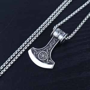 Macro detail of Nordic Viking axe pendant with Celtic knotwork and Kolovrat sun wheel symbol