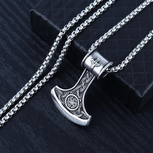Macro detail of silver Viking battle axe pendant with Slavic Kolovrat engraving and chain