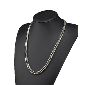 Détail d'un collier à mailles cubaines en acier inoxydable argenté sur buste noir