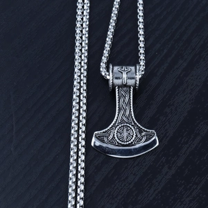 Macro shot of a silver Slavic Mjolnir pendant with Celtic knots and Kolovrat symbol