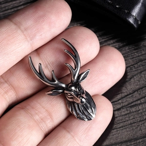 Vintage stainless steel stag deer head pendant shown in hand for size comparison