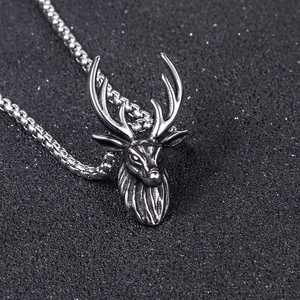 Detailed close-up of a vintage silver stag head pendant with intricate antler textures