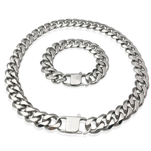Close-up of polished silver Cuban link chain necklace and bracelet set with secure clasp