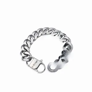 Close-up of stainless steel Cuban link bracelet with custom logo on lobster clasp