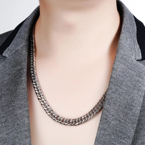 Gepolijste zilveren cubaanse schakelketting voor heren gestyled met een grijze blazer
