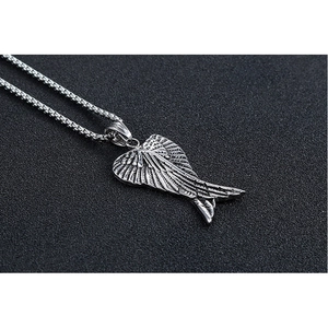 Detailed macro view of vintage stainless steel angel wing pendant with an antique finish