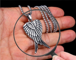 Macro shot of silver angel wing heart pendant necklace on a polished box chain