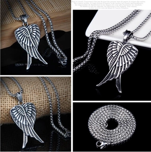 Macro detail of gothic angel wing heart pendant in antique silver finish on chunky metal chain