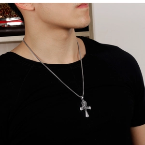 Detail of silver Ankh cross pendant with vintage textures on a stainless steel chain