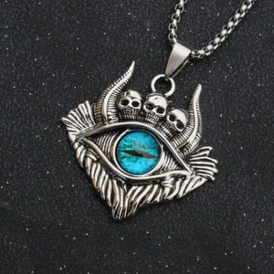 Macro shot of gothic evil eye necklace with three skulls and blue glass eyeball pendant