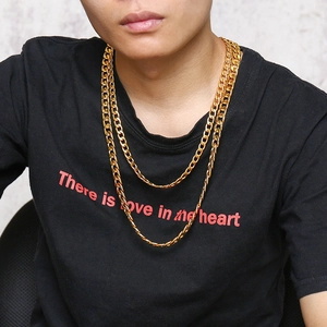 Nahaufnahme von doppellagigen goldenen Panzerketten an einem männlichen Modell im T-Shirt