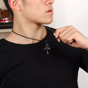 Close-up of black Ankh cross pendant with intricate texture on a beaded chain