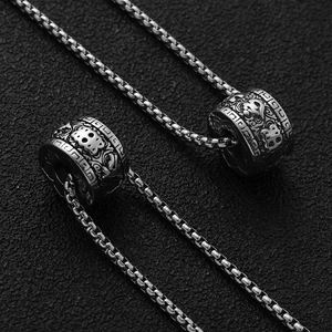Vintage stainless steel cylindrical pendant with intricate relief carvings and box chain