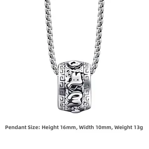 Detailed macro view of vintage stainless steel cylinder pendant with intricate carvings