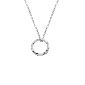 Macro detail of silver Mobius ring pendant with engraved HERE and ROAD text