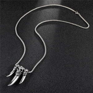 Gros plan du pendentif crâne avec dents pointues sur une chaîne à mailles carrées