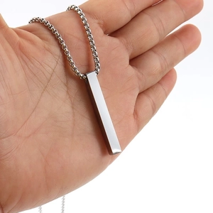 Detailed view of hand holding a polished silver rectangular bar pendant necklace