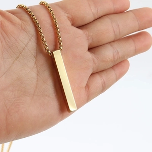Detailed close-up of a polished gold-colored rectangular column pendant on a box chain