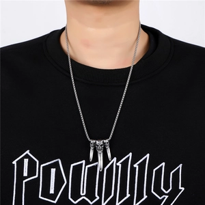 Détail du pendentif dent de crâne punk argenté avec trois pointes sur chaîne en acier