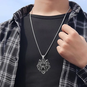 Detailed shot of a vintage titanium steel wolf head pendant on a male model with a black shirt