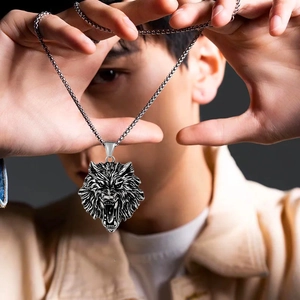 Detailed close-up of a vintage silver wolf head pendant with punk rock engraving and chain