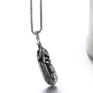 Macro shot of punk style stainless steel pendant featuring eagle claw and feather detail