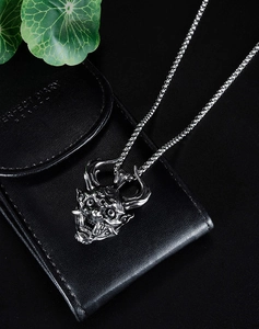 Detailed close-up of a silver stainless steel Hannya demon mask pendant with box chain