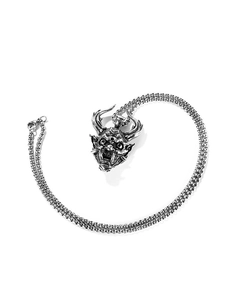 Macro shot of vintage silver Hannya demon pendant on a thick stainless steel box chain