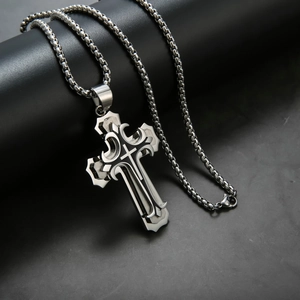 Vue macro du pendentif croix en acier inoxydable avec textures métalliques sculptées