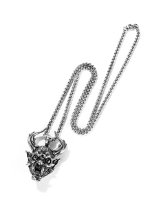 Macro shot of retro silver Hannya mask pendant with box chain in hip hop punk style