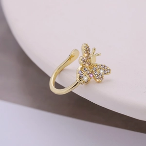 Macro view of gold bee ear cuff with micro-pave cubic zirconia on ceramic edge
