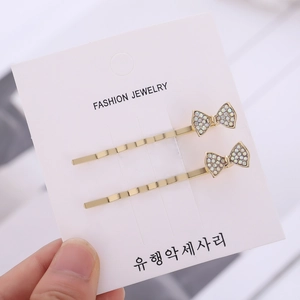 Elegante set di due fermagli per capelli dorati con fiocco in strass scintillanti