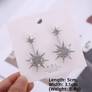 Detail shot showing 5cm x 3.1cm dimensions of silver snowflake star earrings with rhinestones