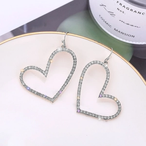 Macro view of heart-shaped hollow earrings with multicolor sparkling rhinestones