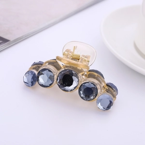 Champagne crystal hair claw clip with vintage blue gems on a minimalist white table