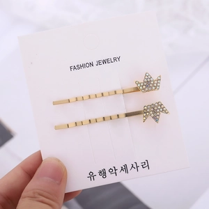 Lot de deux barrettes à cheveux couronne dorée avec strass irisés sur carte blanche