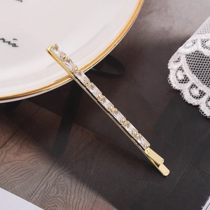 Elegant gold-tone bobby pin with rectangular cubic zirconia stones on white background