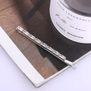 Elegant silver hair clip with ten rectangular cubic zirconia stones on magazine background