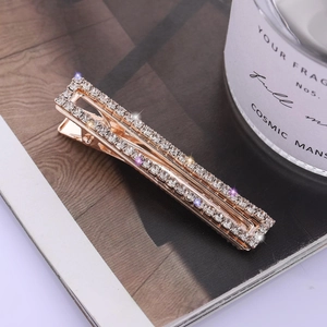 Eleganter goldener Haarclip mit vier Reihen funkelnder Strasssteine auf einem Magazin