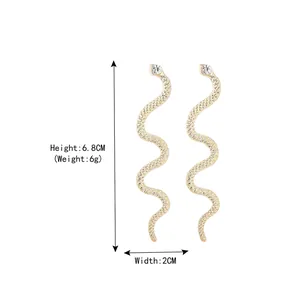 Golden snake-shaped long drop earrings with white rhinestone detail and wavy metal texture