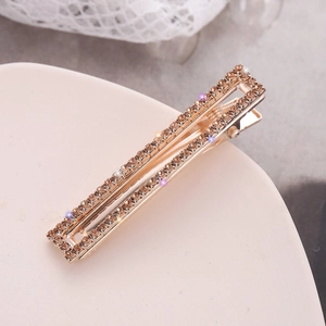 Funkelnde Haarklammer mit champagnerfarbenen Strasssteinen auf Spitzenhintergrund