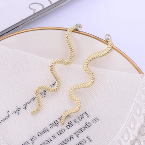 Exaggerated golden snake drop earrings with sparkling rhinestones in an elegant S-curve design