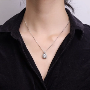 Collier élégant avec pendentif carré en zircone porté sur un fond de chemise en velours noir