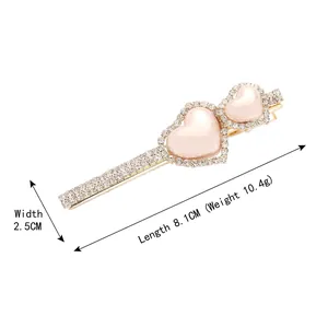 Elegante fermaglio per capelli dorato con due cuori rosa pesca e strass brillanti da donna