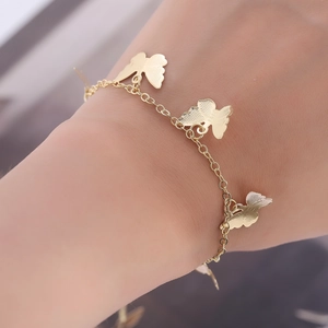 Golden butterfly charm anklet with textured metallic pendants for elegant women