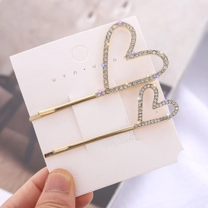 Baroque style gold heart hair clips set with sparkling white rhinestones on card
