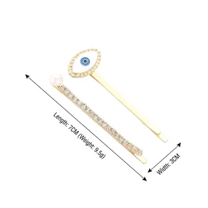 Creative evil eye hair clip set with white rhinestones and pearls in gold finish