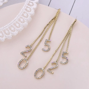 Élégantes boucles d'oreilles pendantes dorées avec pampilles numéro 520 et strass brillants