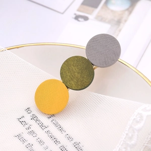 Detail showing the matte finish geometric round hair clip with three-color resin design